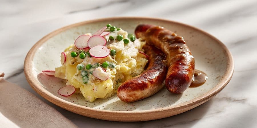 Bratwurst mit Zwiebelsauce und buntem Kartoffelsalat
