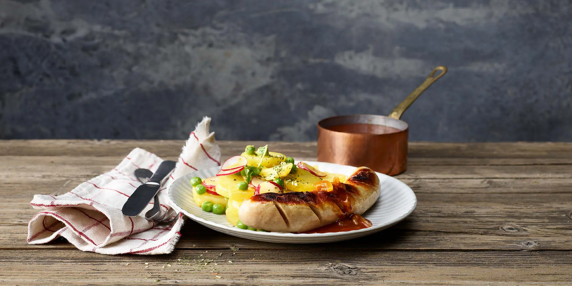 Bratwurst mit Zwiebelsauce und buntem Kartoffelsalat